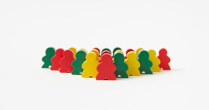 Holzspielzeugfiguren, die in Reihen vor einem schlichten Hintergrund angeordnet sind